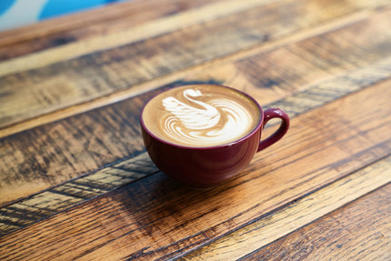 Cup with latte art on a wooden table