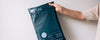 Person holding navy blue mailer bag