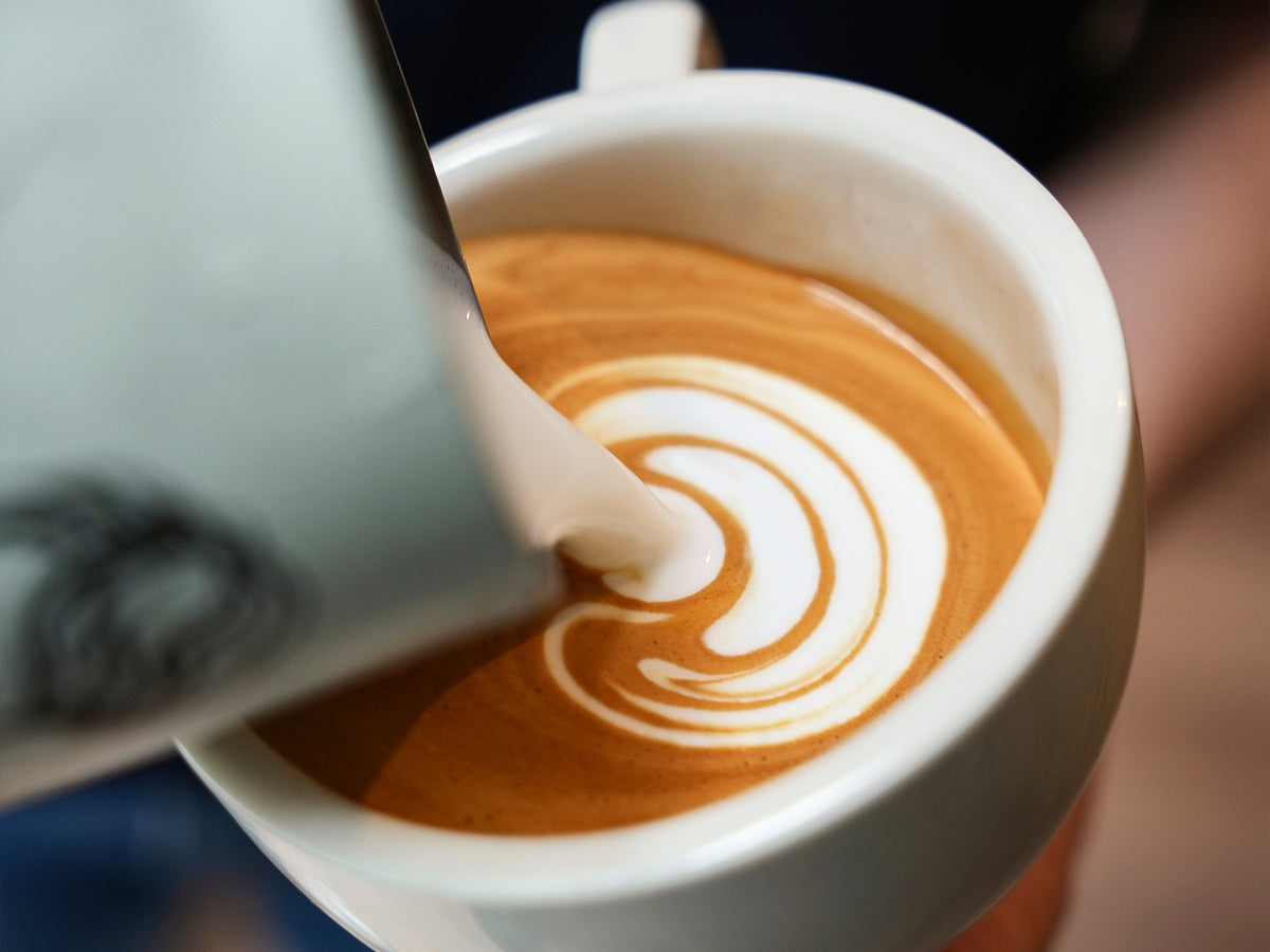 Pouring latte art into a mug